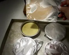 Step <p>Retire el papel aluminio, tape los ramekines tibios con plástico film y refrigere por 2 horas.(ha de obtener textura flan)</p> illustration