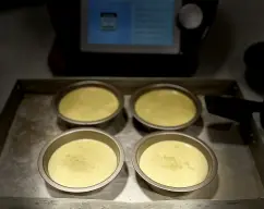 Step <p>Divida la mezcla en 6 ramekines o tartaleta (apta para hornear )colóquelos en un baño María (ver tip), cubra con papel aluminio y hornee por 40 minutos (150°C). Retire del horno y deje enfriar (aprox. 15 minutos).</p> illustration